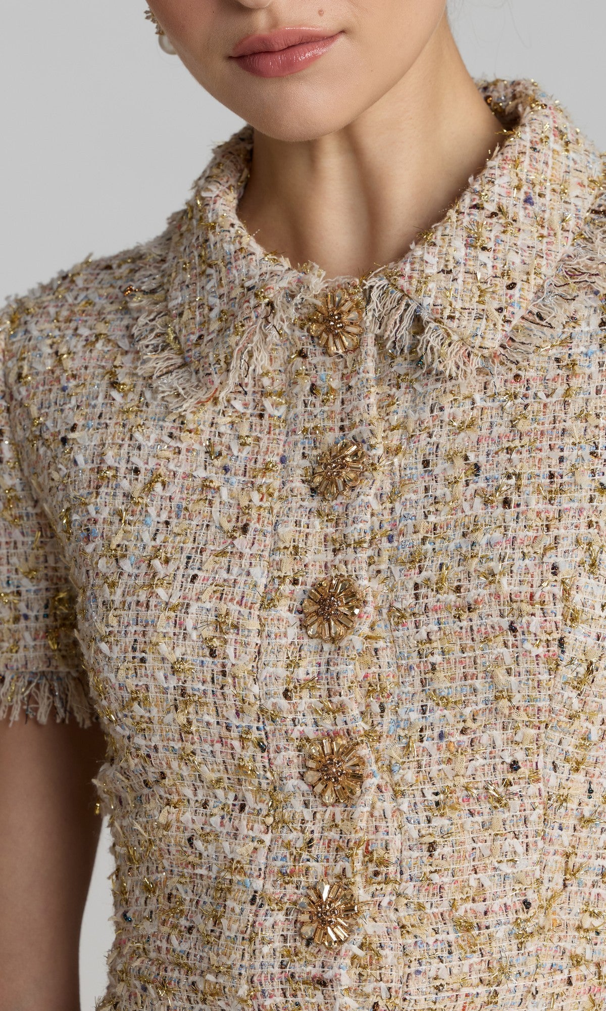 Close-up of a person wearing the Mac Duggal 21222 Midi Party Dress, featuring a textured, multicolored tweed boucle fabric, short sleeves, rhinestone buttons, and a frayed collar.